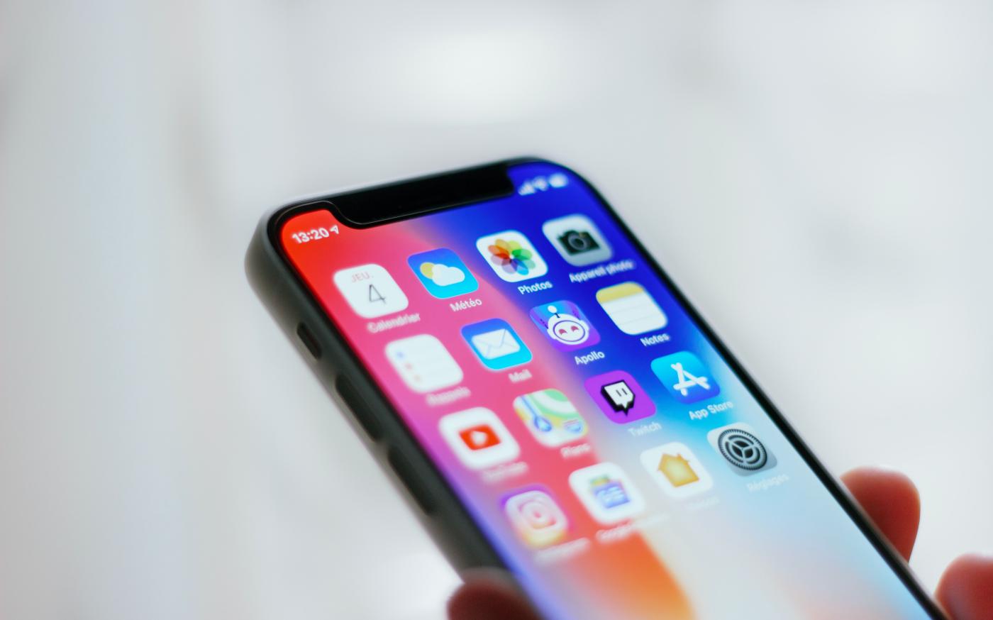 person holding black iphone 4 by Adrien courtesy of Unsplash.